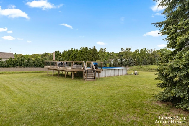 7300 Orchard View Dr NE, Rockford, MI 49341 - view of grassy yard featuring a wooden deck and an outdoor pool