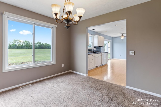 7300 Orchard View Dr NE, Rockford, MI 49341 - unfurnished room with a chandelier, light colored carpet, a sink, baseboards, and a ceiling fan