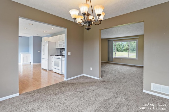 7300 Orchard View Dr NE, Rockford, MI 49341 - unfurnished room with light colored carpet, a chandelier, baseboards, and recessed lighting