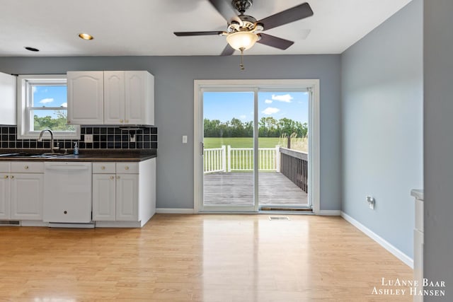 7300 Orchard View Dr NE, Rockford, MI 49341 - kitchen with dishwasher, a sink, dark countertops, light wood-style flooring, and recessed lighting