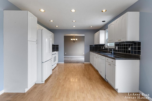 7300 Orchard View Dr NE, Rockford, MI 49341 - kitchen with white appliances, a chandelier, a sink, dark countertops, and tasteful backsplash