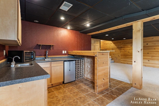 7300 Orchard View Dr NE, Rockford, MI 49341 - kitchen with dark countertops, refrigerator, light brown cabinetry, wooden walls, and recessed lighting