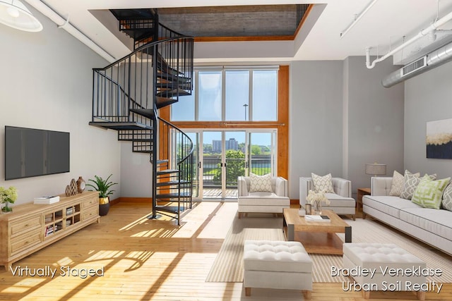 600 Broadway Ave NW Unit 414, Grand Rapids, MI 49504 - living area featuring wood-type flooring, stairway, baseboards, and a towering ceiling