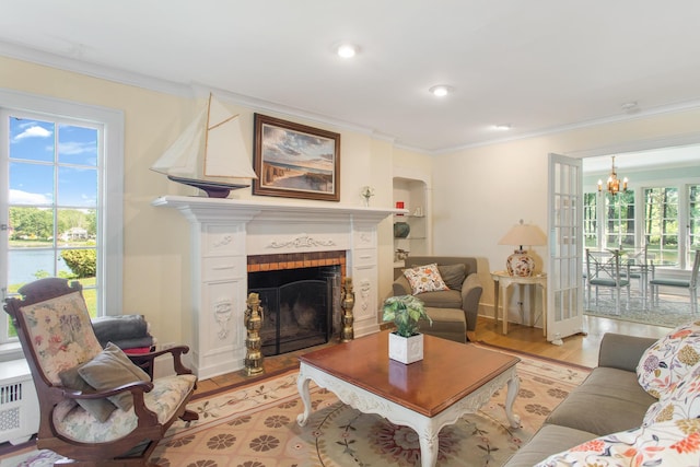 18957 N Fruitport Rd, Spring Lake, MI 49456 - living area with light wood-style floors, ornamental molding, a chandelier, radiator heating unit, and a fireplace with flush hearth