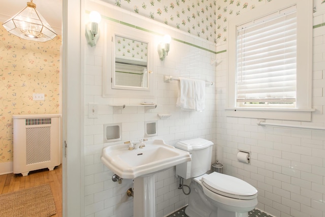 18957 N Fruitport Rd, Spring Lake, MI 49456 - half bath with radiator, wallpapered walls, wood finished floors, and toilet
