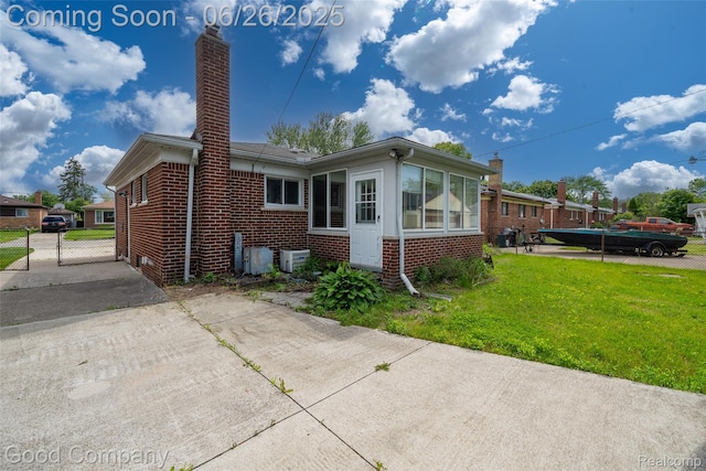 26730 W Davison, Redford, MI 48239 - view of home's exterior with brick siding, a chimney, concrete driveway, and a gate