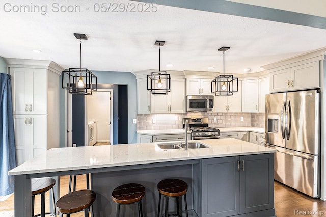 1411 Vollar Dr, Flint, MI 48532 - kitchen featuring stainless steel appliances, a sink, decorative backsplash, a breakfast bar, and light stone countertops