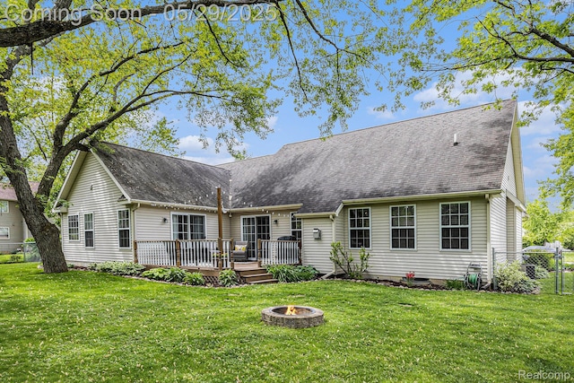 1411 Vollar Dr, Flint, MI 48532 - back of house featuring an outdoor fire pit, a wooden deck, and a shingled roof