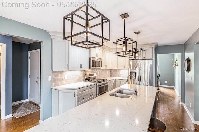 1411 Vollar Dr, Flint, MI 48532 - kitchen with stainless steel appliances, a sink, a chandelier, dark wood-type flooring, and baseboards
