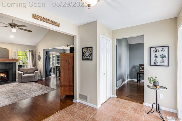 1411 Vollar Dr, Flint, MI 48532 - foyer with a tiled fireplace, lofted ceiling, a ceiling fan, baseboards, and light wood-style flooring