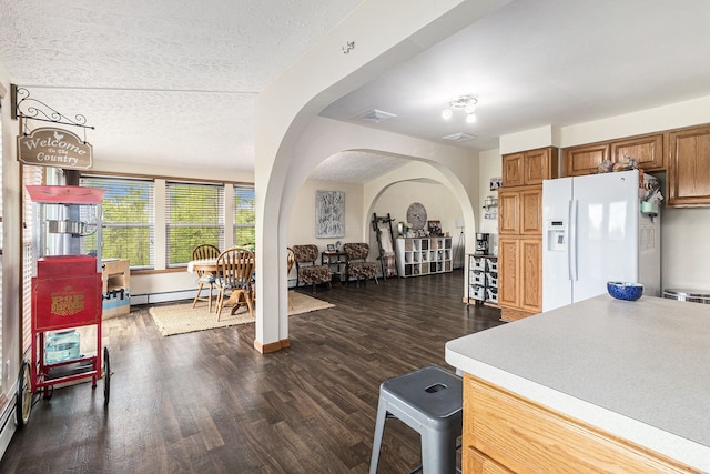 1977 Shipman Rd, Oxford, MI 48371 - kitchen featuring white fridge with ice dispenser, arched walkways, baseboard heating, dark wood finished floors, and light countertops