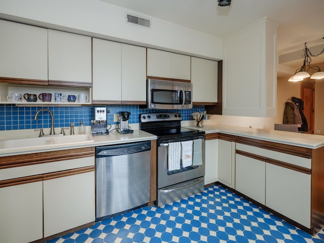 471 W S St Unit 207, Kalamazoo, MI 49007 - kitchen featuring stainless steel appliances, a sink, white cabinets, and light countertops