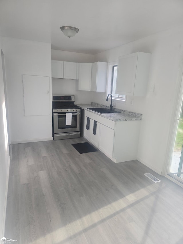 5406 Bermuda Ln, Flint, MI 48505 - kitchen featuring stainless steel range, a sink, white cabinets, and plenty of natural light