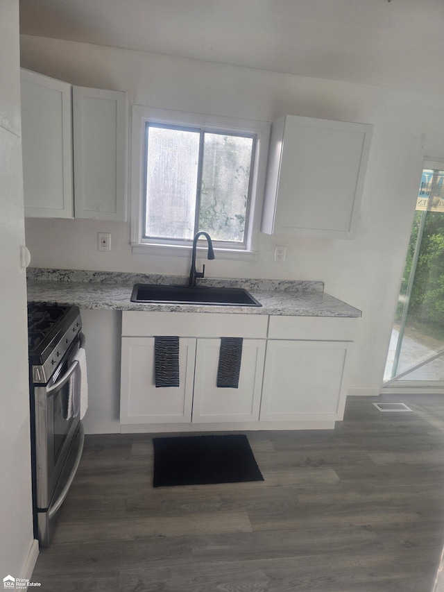 5406 Bermuda Ln, Flint, MI 48505 - kitchen featuring a sink, stainless steel gas stove, white cabinetry, light stone countertops, and dark wood-style flooring