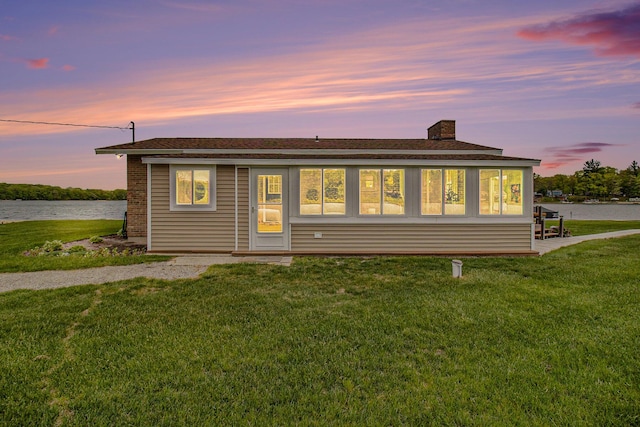 7394 N Keating Dr, Walkerville, MI 49459 - view of front of house with a water view, a yard, a chimney, and a shingled roof