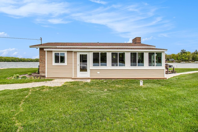 7394 N Keating Dr, Walkerville, MI 49459 - view of front facade featuring a chimney, a water view, a front lawn, and a shingled roof