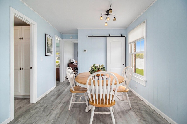 7394 N Keating Dr, Walkerville, MI 49459 - dining space with a barn door, crown molding, wood finished floors, and baseboards