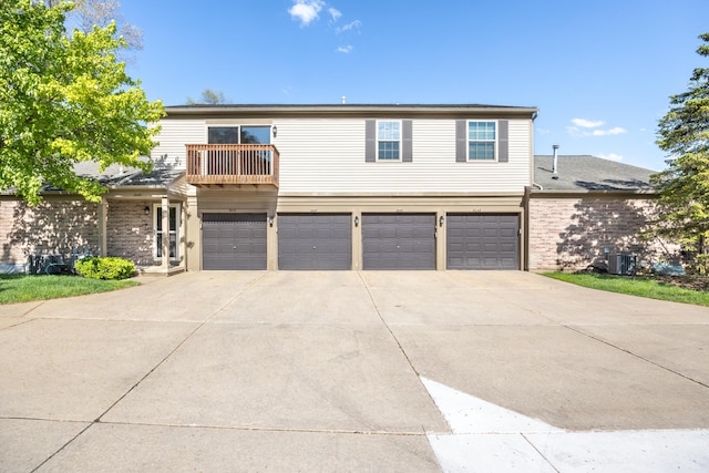 3049 Forest Creek Ct, Ann Arbor, MI 48108 - view of front facade featuring a garage, concrete driveway, a balcony, brick siding, and central AC unit