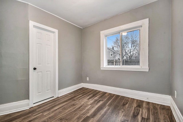 407 11th St NW Unit 409, Grand Rapids, MI 49504 - spare room featuring dark wood-type flooring and baseboards