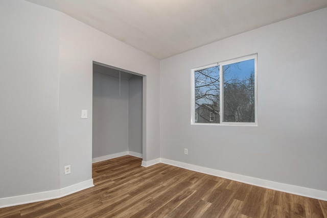 407 11th St NW Unit 409, Grand Rapids, MI 49504 - unfurnished bedroom featuring dark wood-style flooring and baseboards