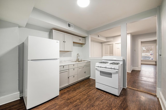 407 11th St NW Unit 409, Grand Rapids, MI 49504 - kitchen featuring white appliances, dark wood-style floors, a sink, baseboards, and light countertops