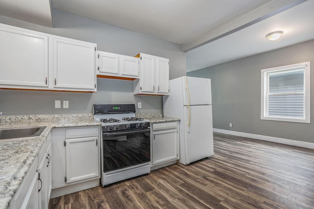 407 11th St NW Unit 409, Grand Rapids, MI 49504 - kitchen featuring gas range, freestanding refrigerator, dark wood finished floors, and white cabinetry