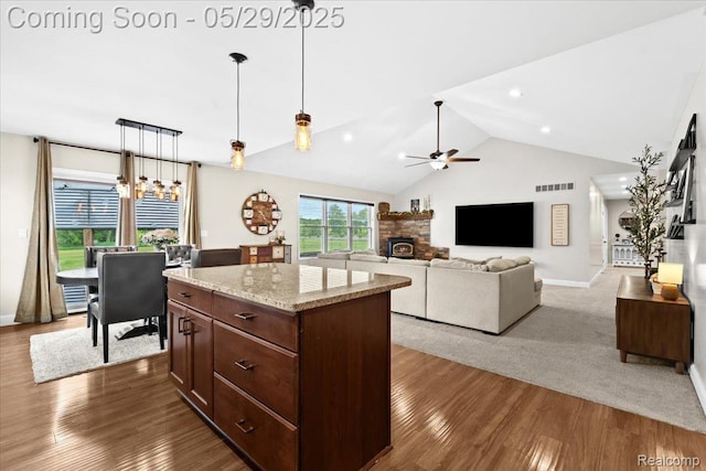 6035 Beard Rd, Byron, MI 48418 - kitchen with a fireplace, a ceiling fan, hanging light fixtures, a chandelier, and wood finished floors