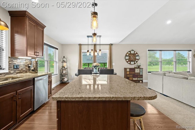 6035 Beard Rd, Byron, MI 48418 - kitchen featuring dishwasher, a kitchen island, open floor plan, tasteful backsplash, and light stone countertops
