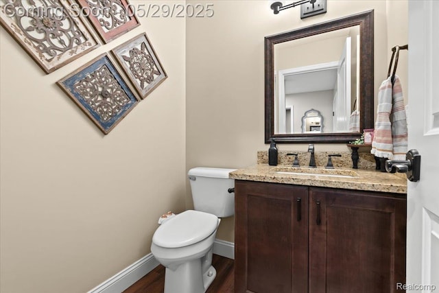 6035 Beard Rd, Byron, MI 48418 - bathroom with vanity, toilet, baseboards, and wood finished floors
