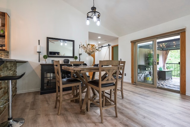 2363 Sundance Rdg, Howell, MI 48843 - dining space with light wood-type flooring, a barn door, lofted ceiling, and baseboards