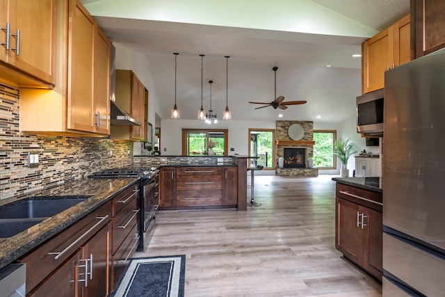 2363 Sundance Rdg, Howell, MI 48843 - kitchen featuring appliances with stainless steel finishes, a ceiling fan, light wood-type flooring, tasteful backsplash, and a peninsula
