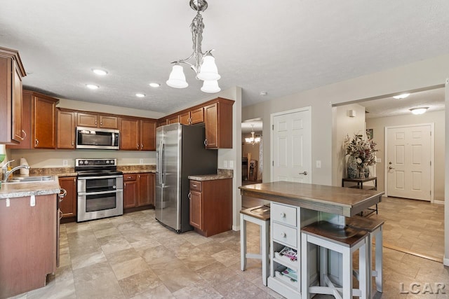 10623 Springville Hwy, Onsted, MI 49265 - kitchen featuring stainless steel appliances, a chandelier, a sink, brown cabinets, and recessed lighting