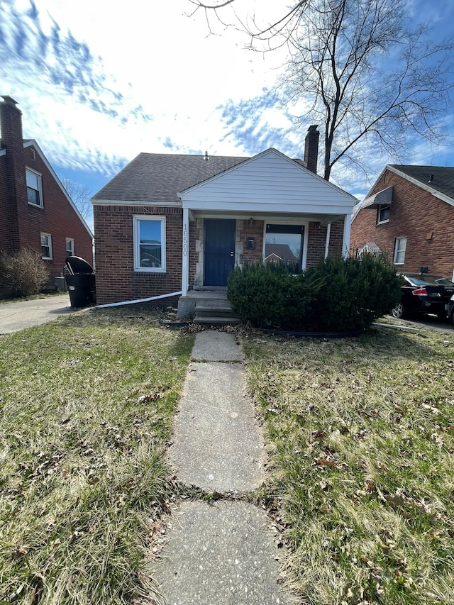 16500 Eastburn St, Detroit, MI 48205 - bungalow featuring brick siding, a front yard, and a chimney