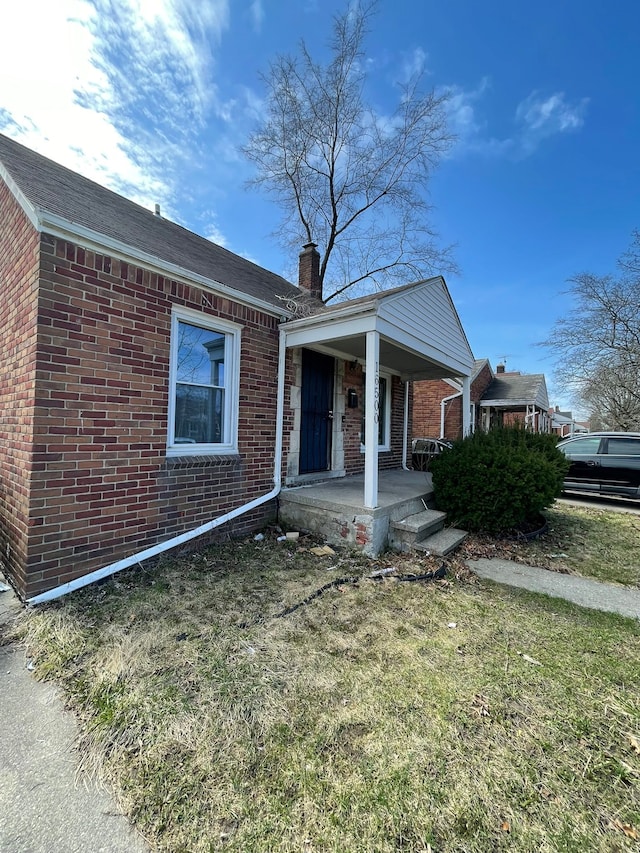 16500 Eastburn St, Detroit, MI 48205 - view of front of home featuring brick siding, covered porch, and a chimney