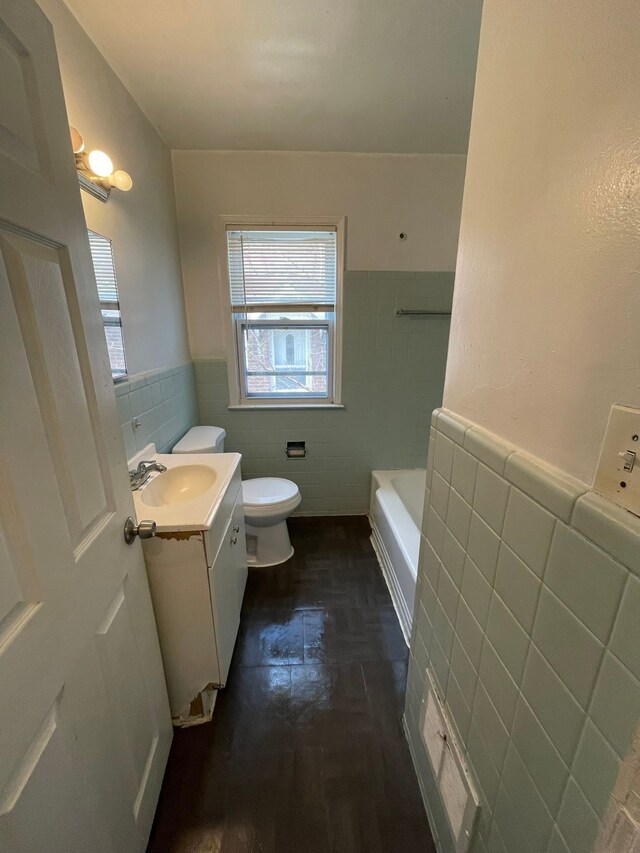 16500 Eastburn St, Detroit, MI 48205 - bathroom with tile walls, toilet, vanity, and a wainscoted wall