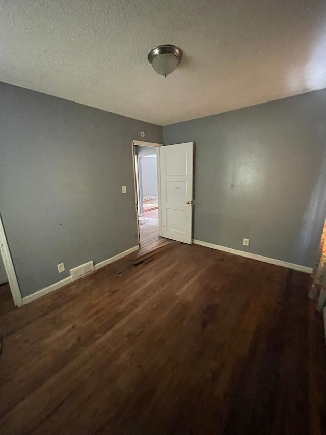 10952 Peerless St, Detroit, MI 48224 - unfurnished bedroom with dark wood finished floors, baseboards, and a textured ceiling