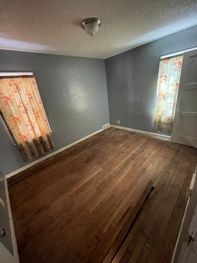 10952 Peerless St, Detroit, MI 48224 - empty room with wood finished floors, a textured ceiling, and baseboards