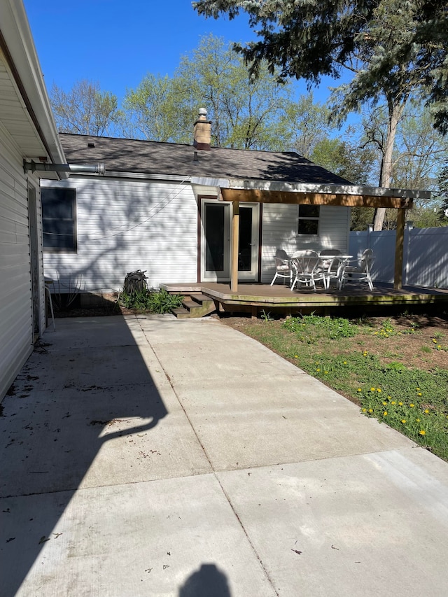 1659 Weymouth St, West Bloomfield, MI 48324 - rear view of house with a deck, a patio area, a chimney, and roof with shingles