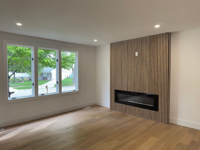 42811 Wilmington Dr, Sterling Heights, MI 48313 - unfurnished living room with wood finished floors, a glass covered fireplace, baseboards, and recessed lighting