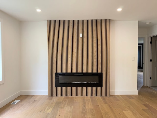 42811 Wilmington Dr, Sterling Heights, MI 48313 - detailed view of a glass covered fireplace, wood finished floors, baseboards, recessed lighting, and a smoke detector