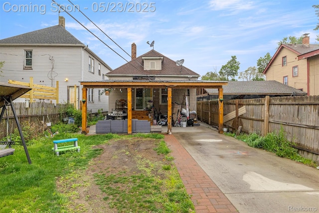 7295 Gartner St, Detroit, MI 48209 - rear view of house with a fenced backyard, an outdoor living space, concrete driveway, and a patio