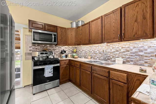 7295 Gartner St, Detroit, MI 48209 - kitchen featuring stainless steel appliances, a sink, light countertops, and backsplash