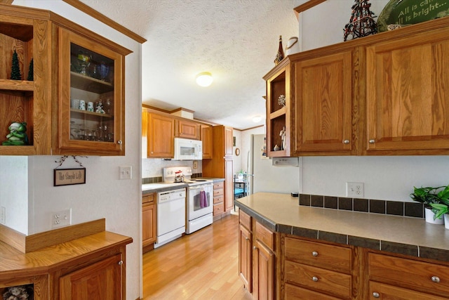 1797 Lawrence Dr, Bitely, MI 49309 - kitchen featuring white appliances, open shelves, light wood finished floors, brown cabinetry, and a textured ceiling