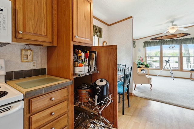 1797 Lawrence Dr, Bitely, MI 49309 - kitchen with white appliances, ornamental molding, ceiling fan, brown cabinetry, and light wood-type flooring