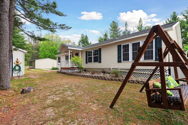 1797 Lawrence Dr, Bitely, MI 49309 - rear view of property with covered porch, a lawn, and an outbuilding