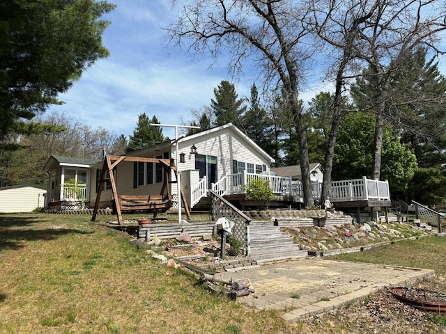 1797 Lawrence Dr, Bitely, MI 49309 - view of front facade with a deck, a front lawn, and stairway