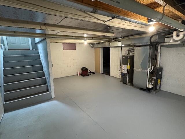 418 N Hemlock St, Evart, MI 49631 - unfinished basement with gas water heater, stairs, and heating unit