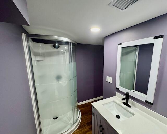 418 N Hemlock St, Evart, MI 49631 - bathroom featuring a shower stall, wood finished floors, vanity, baseboards, and recessed lighting