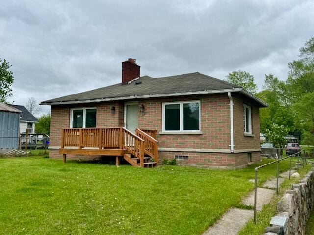 418 N Hemlock St, Evart, MI 49631 - back of property with brick siding, a chimney, a wooden deck, and a shingled roof