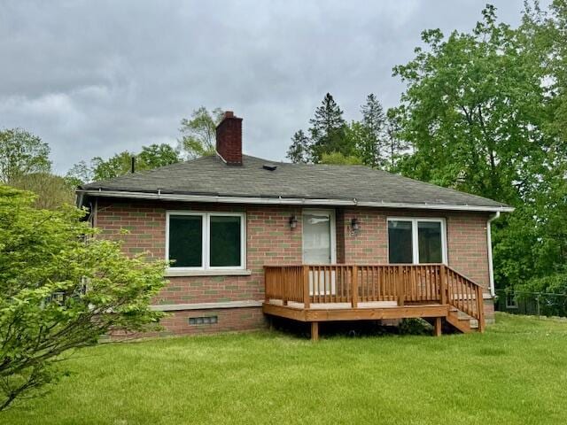 418 N Hemlock St, Evart, MI 49631 - back of house with a deck, brick siding, a yard, a chimney, and a shingled roof